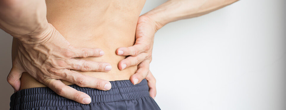 Man grijpt naar zijn pijnlijke rug
