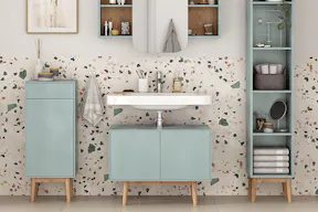 Blaues Badezimmer mit Fronten in der Aquafarbe Türkis, bestehend aus Waschtisch, Regal, Spiegelschrank und Unterschrank vor einer Wand in Terrazzo-Optik.