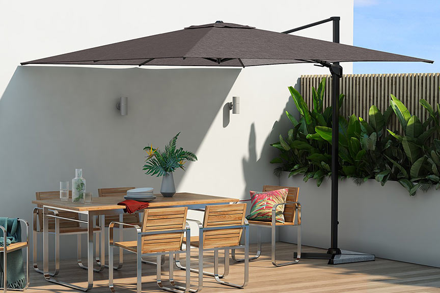 Donkere parasol met in de schaduw een zitgroep van houten meubels