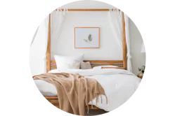 Himmelbett aus Massivholz mit weißen Bettdecken und Tagesdecke in Beige (Online-Shop: home24).