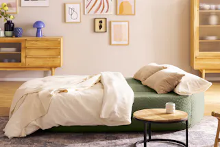 Ausklappbares Schlafsofa in Grün mit Beistelltisch im Industrial-Stil.