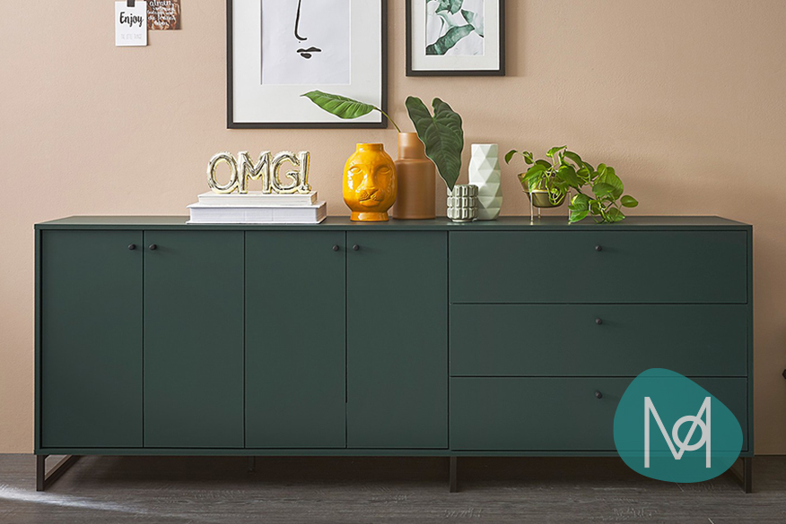 Dunkelgrünes Sideboard der home24 Exklusivmarke Mørteens mit schwarzem Eisengestell und vielen Türen und Schubfächern mit glatten Fronten, welches mit mehreren Vasen, Grünfplanze und goldenen Deko-Elementen dekoriert ist.