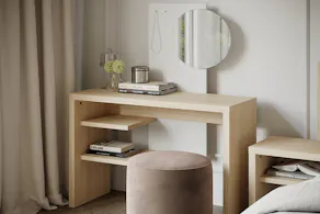 Minimalistischer Schminktisch aus hellem Holz mit rundem Spiegel und hellrosa Pouf davor