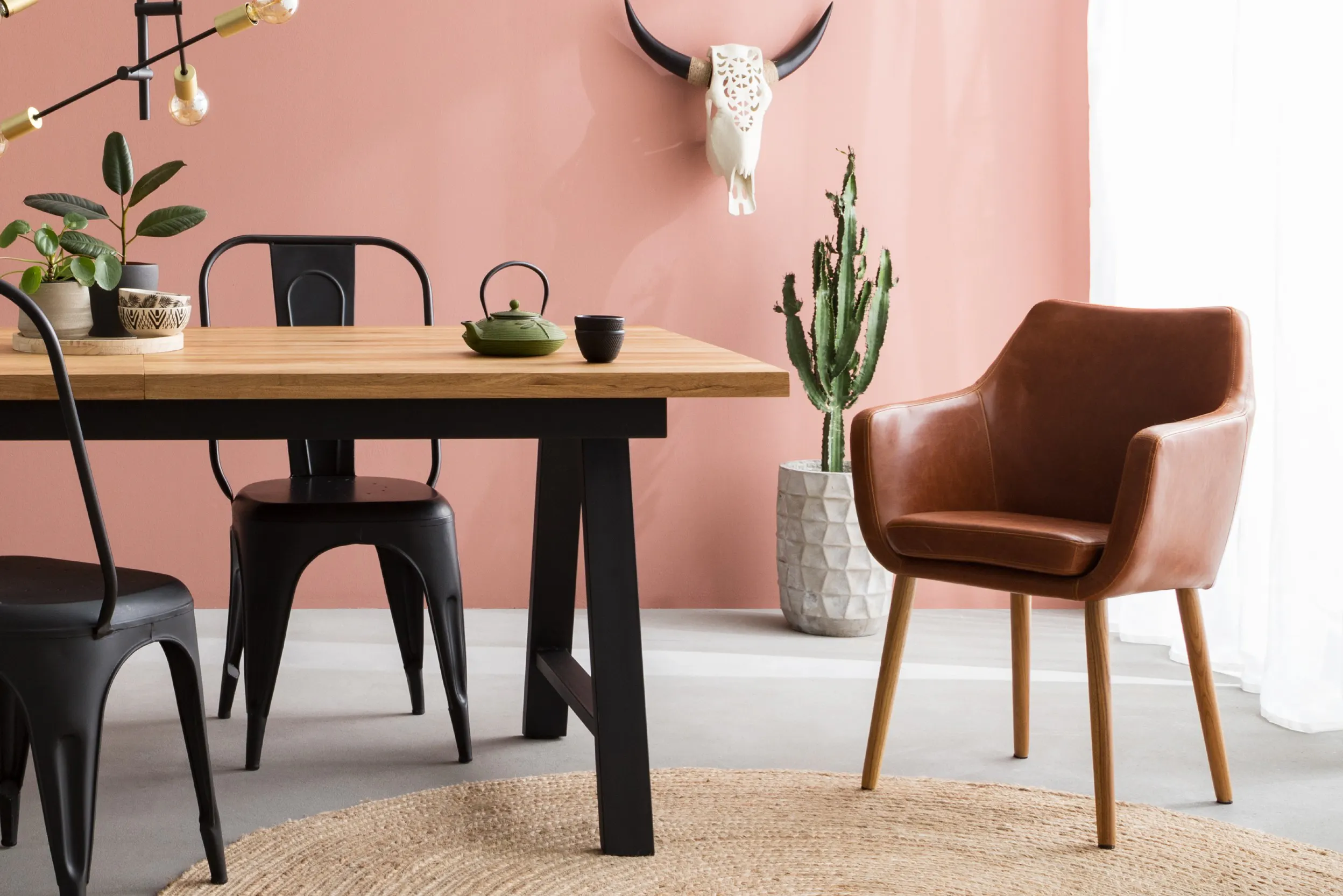 Holztisch mit schwarzen Metallstühlen und gepolsterter Esszimmerstuhl