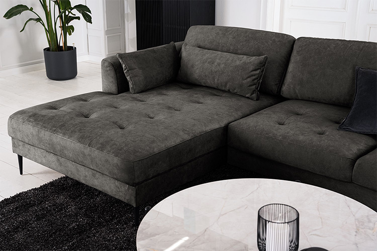 Canapé d'angle gris foncé Gaillon by Studio Copenhagen,au design élégant et sobre, avec des coussins assortis, et combiné à une table basse ronde avec un plateau en marbre blanc.