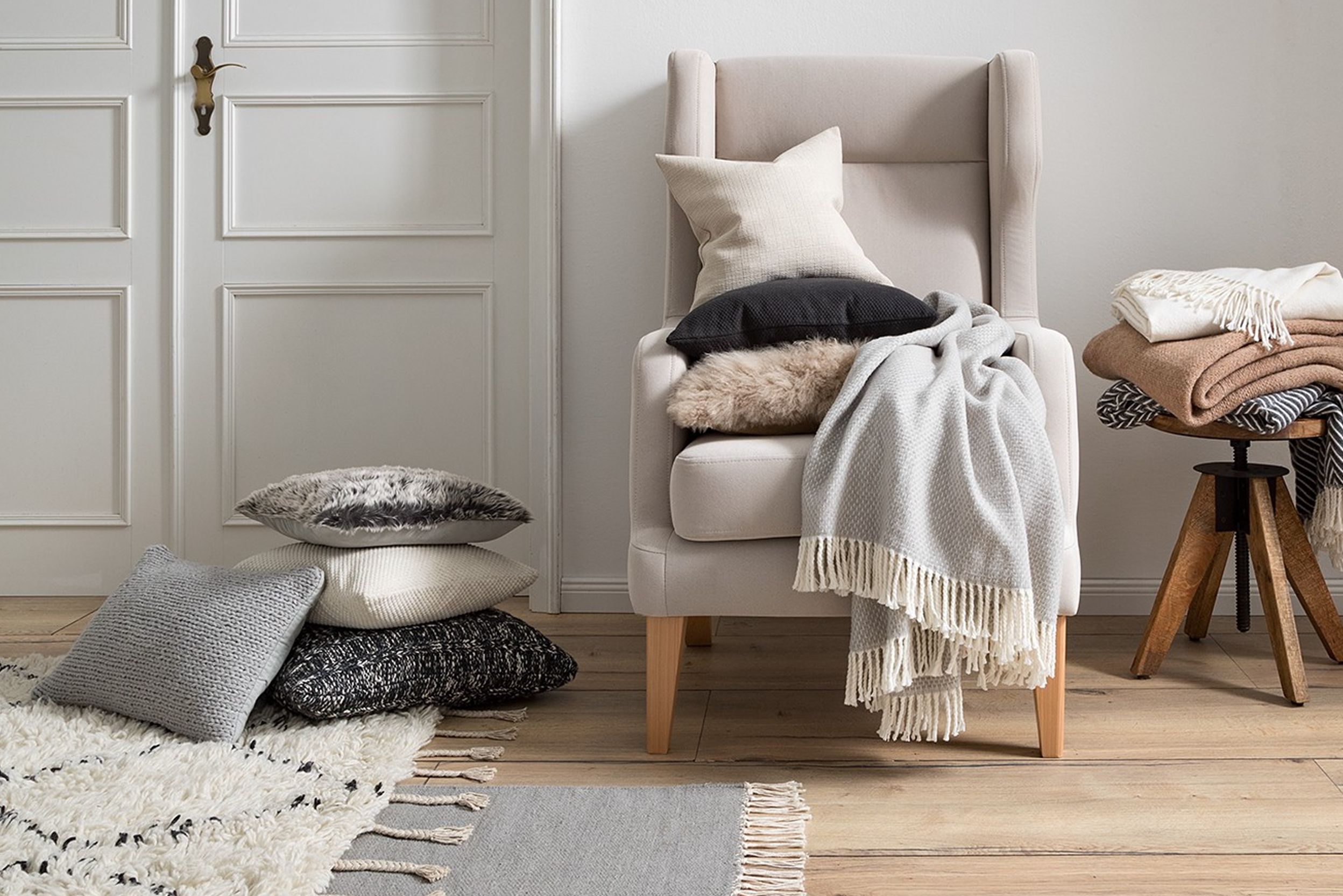 Heller Sessel mit Kissen und Decke zur schnellen Umgestaltung deiner vier Wände