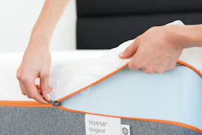Eine Frau beim Öffnen eines Matratzenbezugs