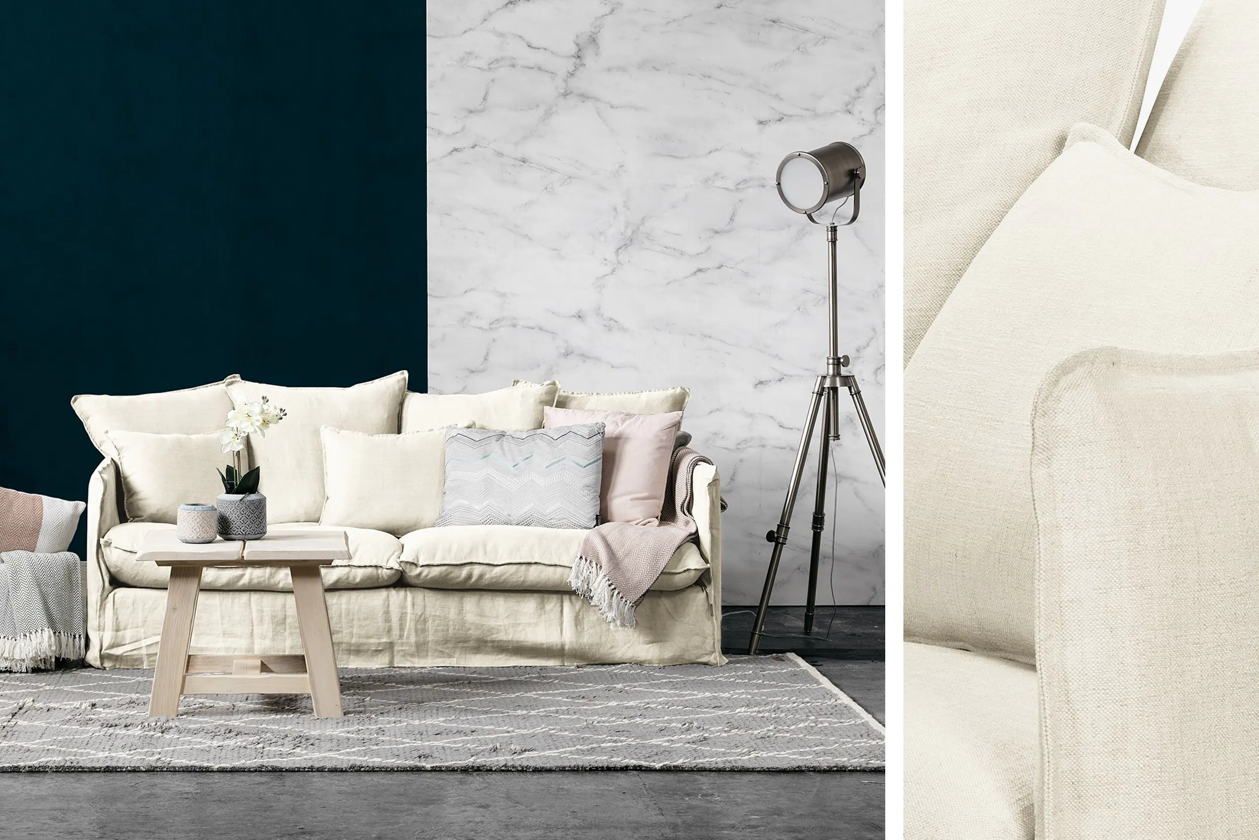 Helles Sofa mit vielen Kissen vor dunkelblauer Wand