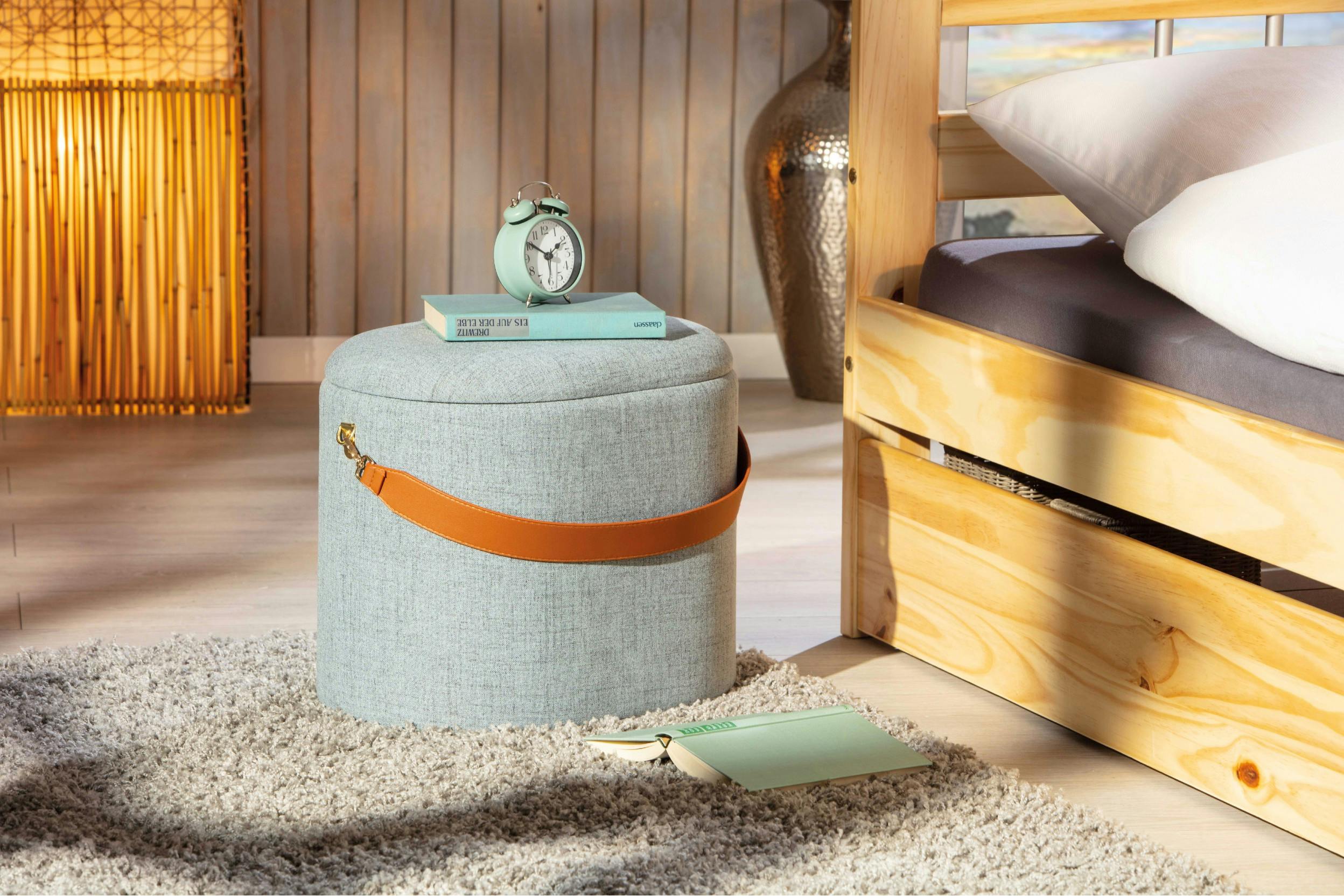 Multifunktionaler Polterhocker mit einem Tragegriff aus hellem Leder