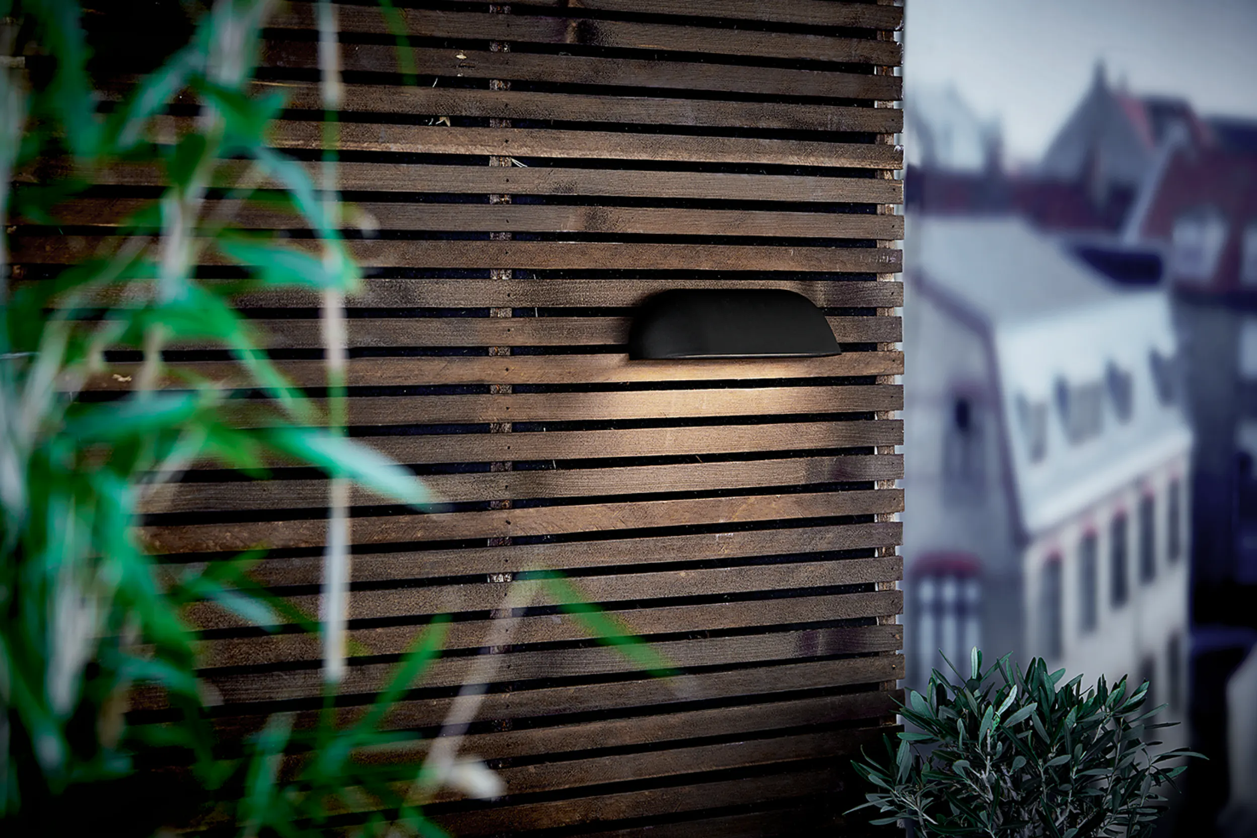 Schlichte Wandleuchte in Schwarz im Garten
