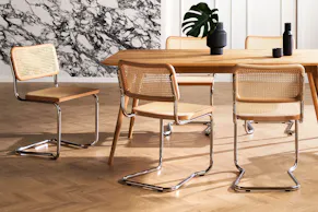 Geschmackvoll eingerichtetes Esszimmer mit Freischwinger Holm aus Wiener Geflecht, heller Buche und Stahlrohr neben Esstisch Sander aus Eichenmassivholz der home24 Exklusivmarke Studio Copenhagen, dazu Pendelleuchten aus Glas von Loistaa.