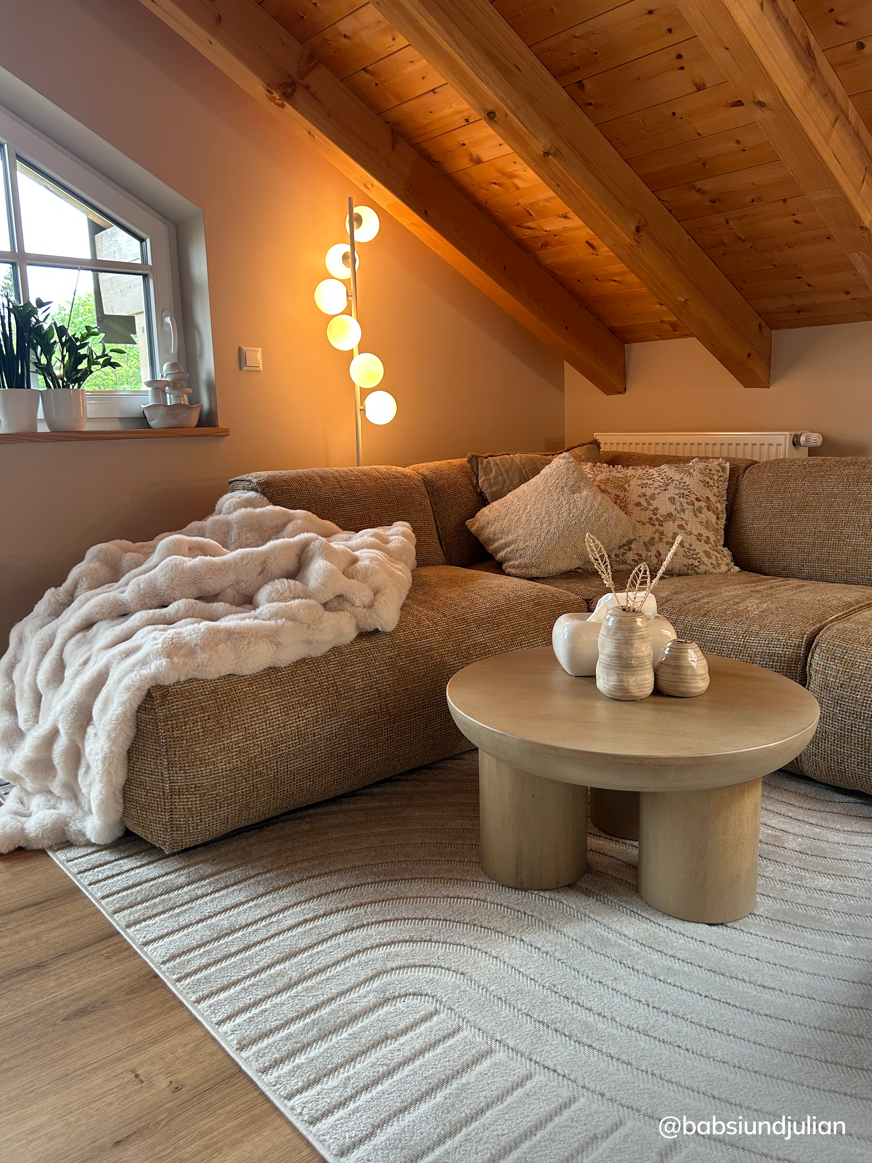 Gemütliches Dachgeschoss-Wohnzimmer mit Stein-Couchtisch und Ecksofa in strukturiertem Honiggelb.