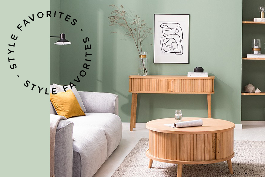 Graues Sofa mit elektrischer Sitztiefenverstellung und Wohnzimmermöbel aus hellem Holz vor einer Wand in Salbeigrün