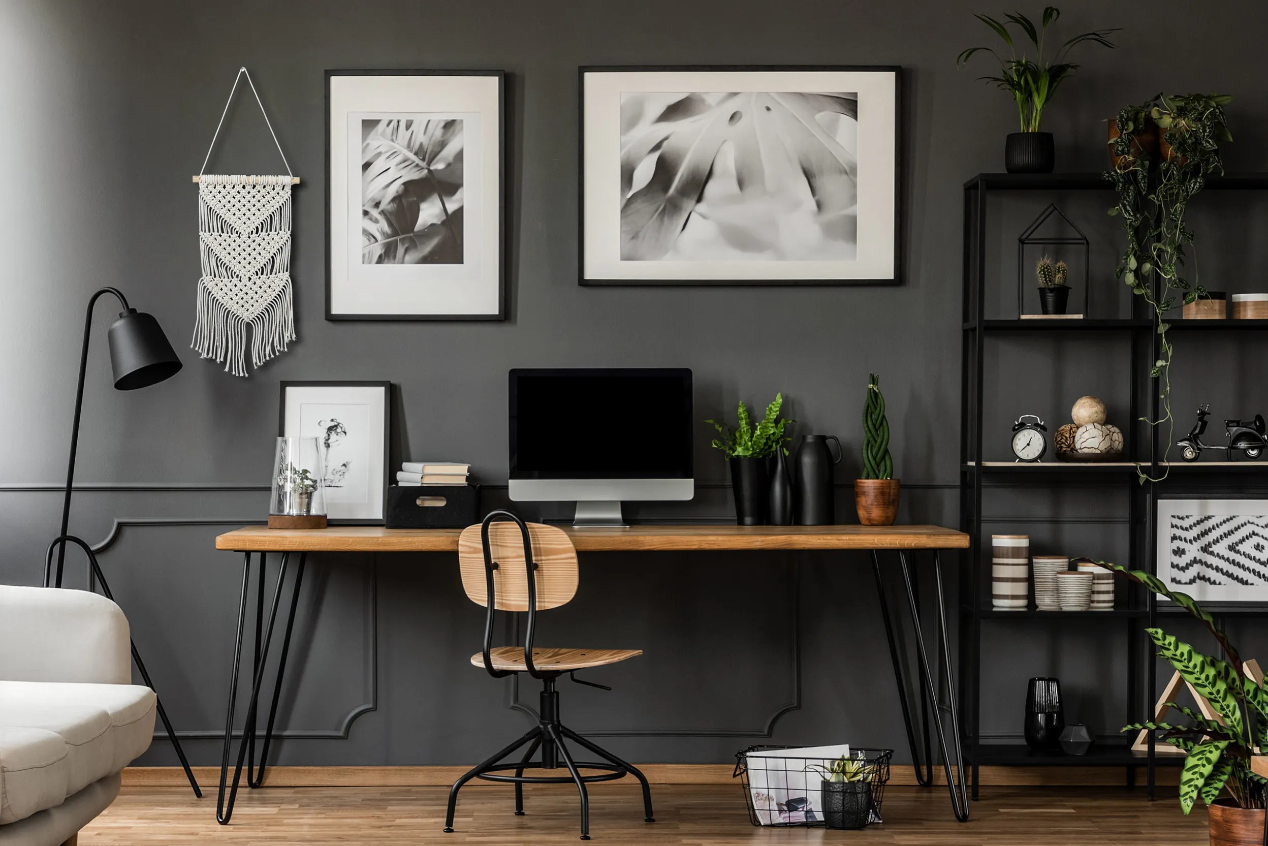 Arbeitsbereich im Industrial-Look mit schwarz-weißen Bildern und passendem Makramee