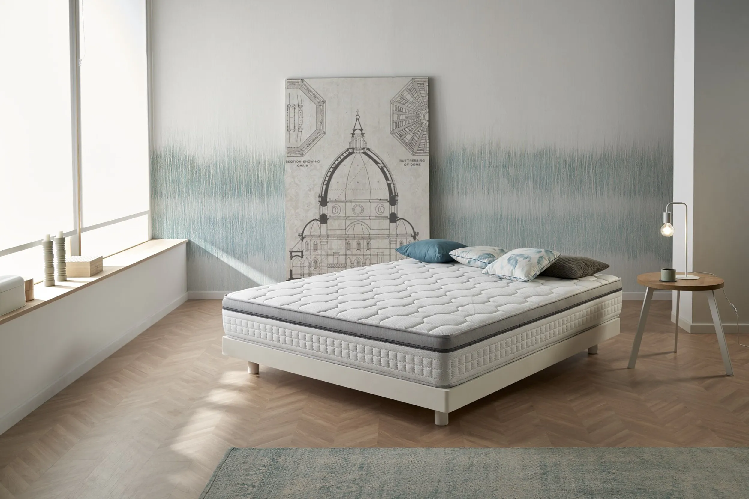 Helles Schlafzimmer mit Parkettboden und Bett mit Federkernmatratze