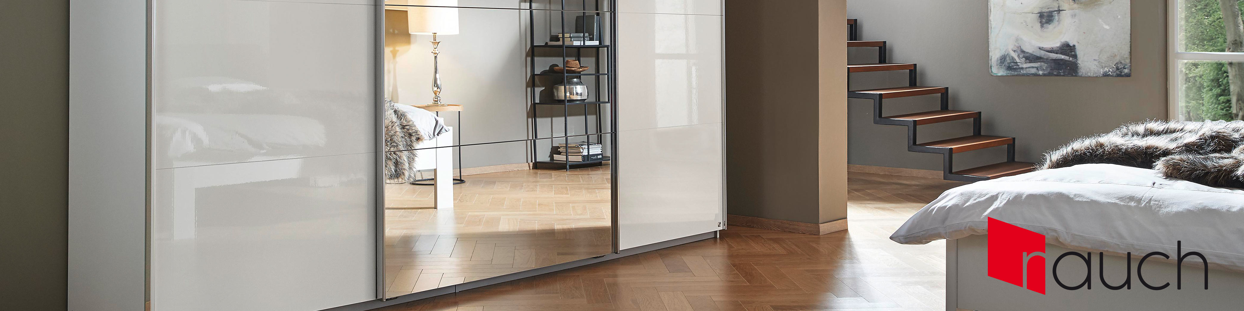 Weißer rauch Schwebetürenschrank mit Spiegeltür; im Hintergrund sind Bett und Treppe zu erkennen