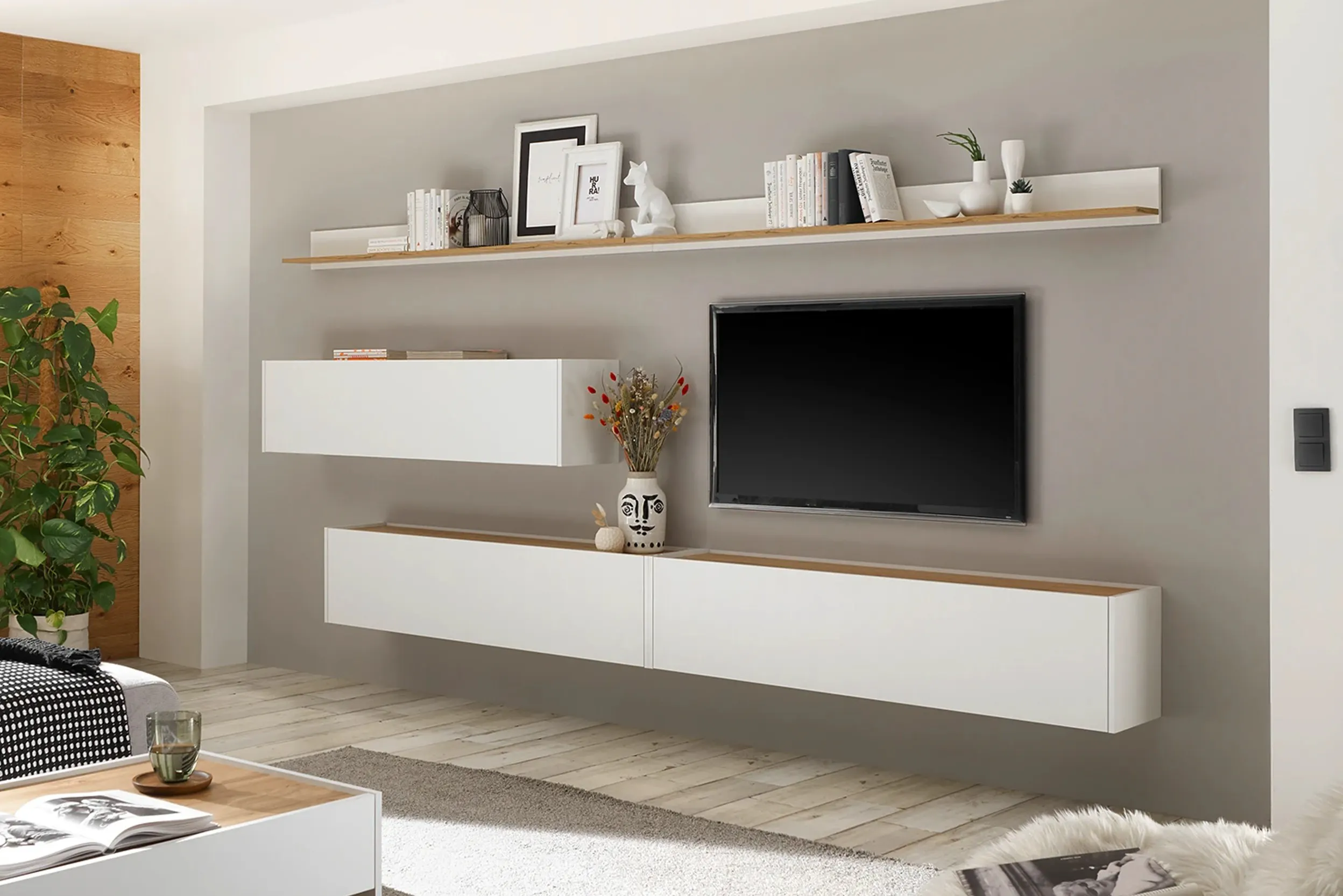 Parete attrezzata modulare in colori chiari. La parete sullo sfondo é grigia. 