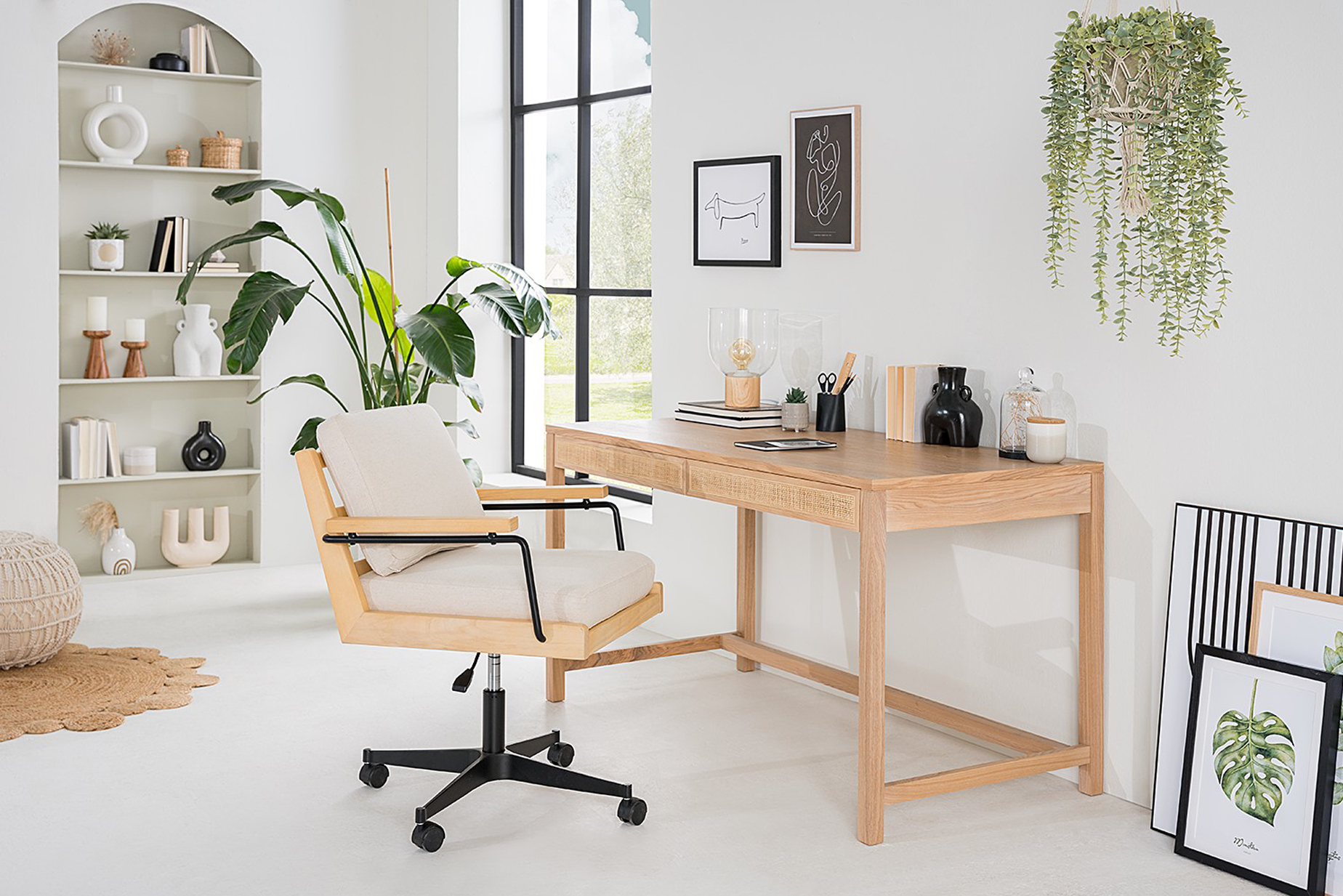 Homeoffice-Ecke in einem Schlafzimmer mit Schreibtisch Taylor und Bürostuhl Taylor der home24 Exklusivmarke kollected. Dazu zwei Grünpflanzen und ein eingelassenes Wandregal mit Deko.