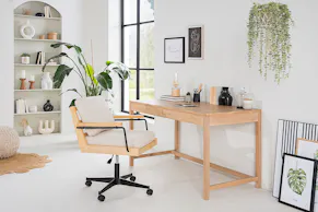 Homeoffice-Ecke in einem Schlafzimmer mit Schreibtisch Taylor und Bürostuhl Taylor der home24 Exklusivmarke kollected. Dazu zwei Grünpflanzen und ein eingelassenes Wandregal mit Deko.