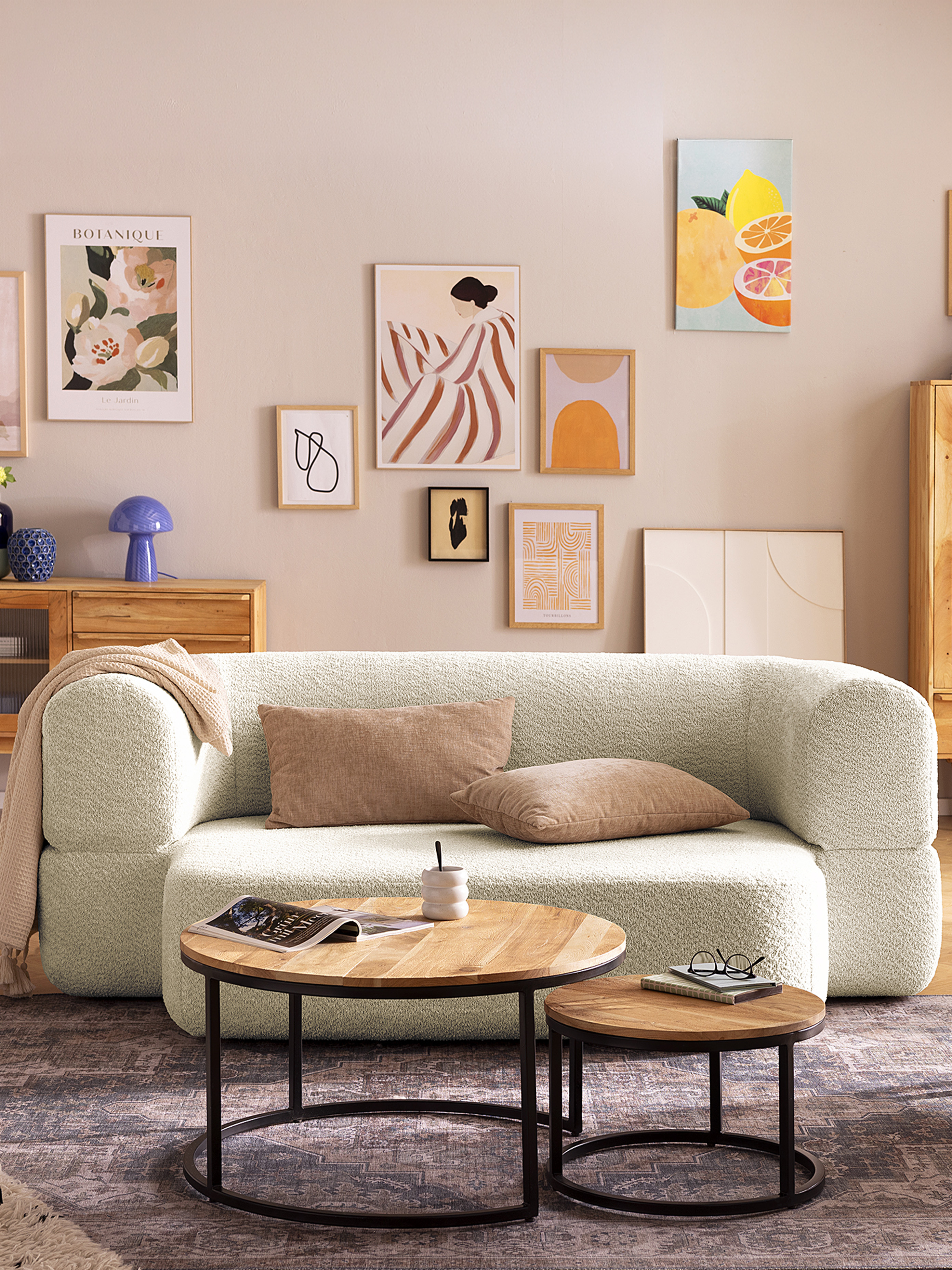 Schlichtes, kleines Wohnzimmer mit hellem Zweisitzer-Sofa.