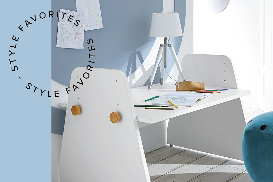 Arbeitsecke im Kinderzimmer mit einem weissem Kinderschreibtisch, der vor einer hellblauen Wand platziert ist und einem offenen Wandregal
