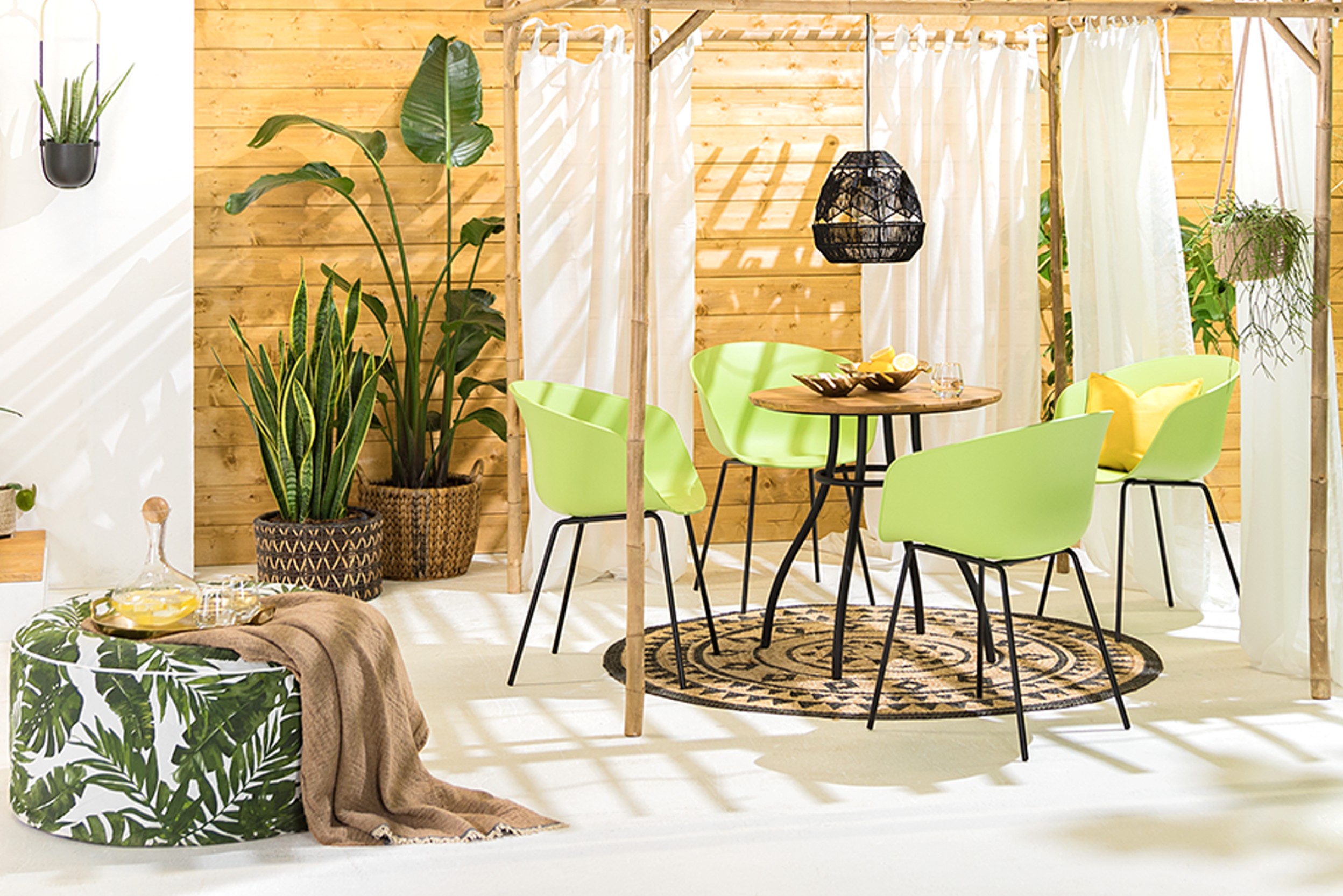 Grüne Gartenstühle aus Kunststoff auf einer geräumigen Terrasse mit vielen Pflanzen