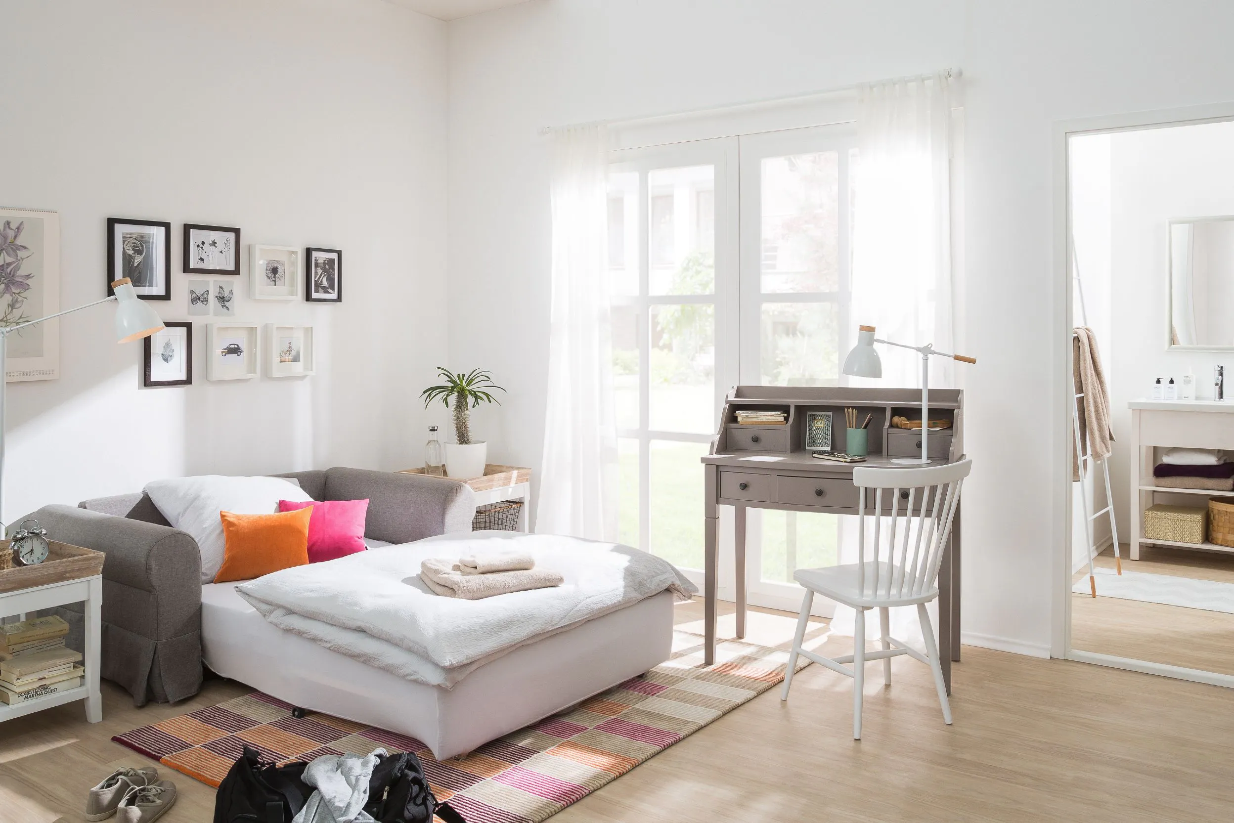 Slaapbank opgemaakt als bed, bureau en stoel