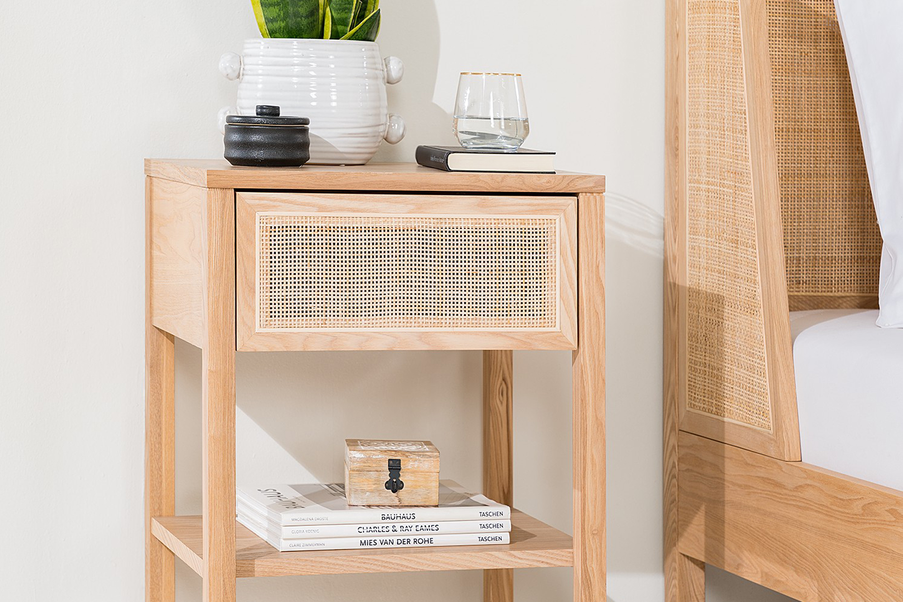 Nachttisch der Serie Taylor by kollected, gefertigt aus Eichenholz und Wiener Geflecht, dekoriert mit einer Topfpflanze in einem weißen Blumentopf.