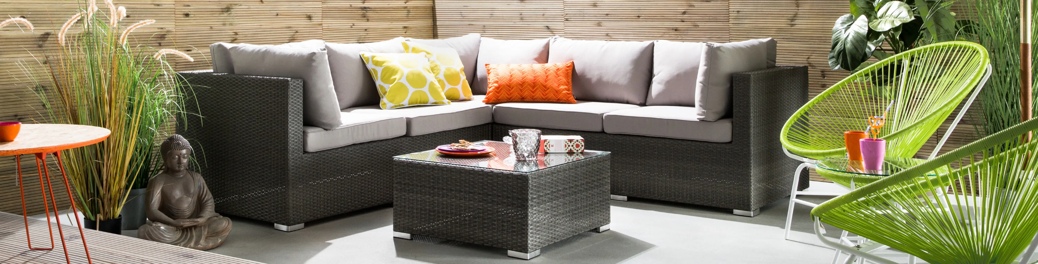 Geräumiges Ecksofa aus Polyrattan mit hellgrauen Polstern und einem Loungetisch im gleichen Design