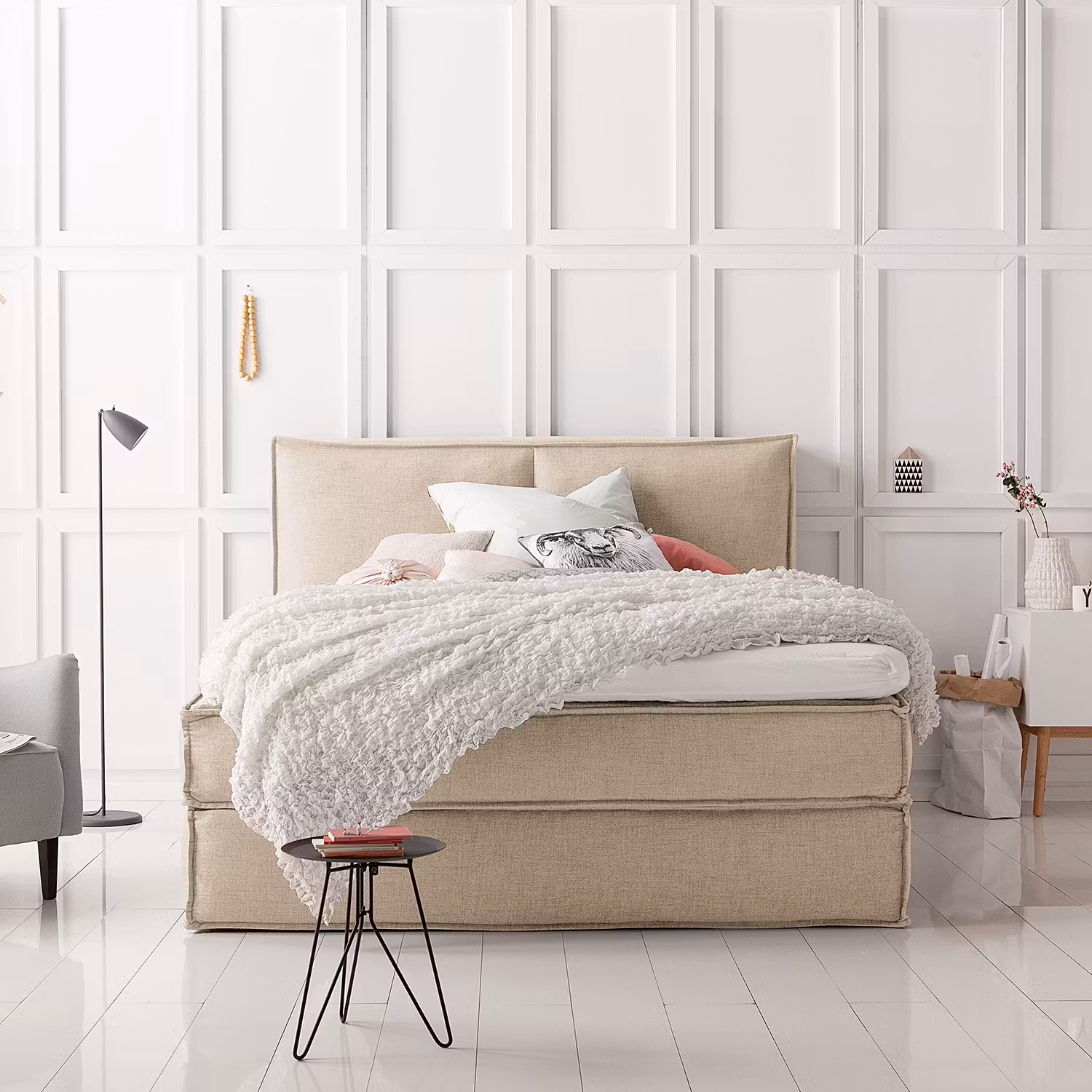 Beiges Boxspringbett KINX mit weißer Bettwäsche.