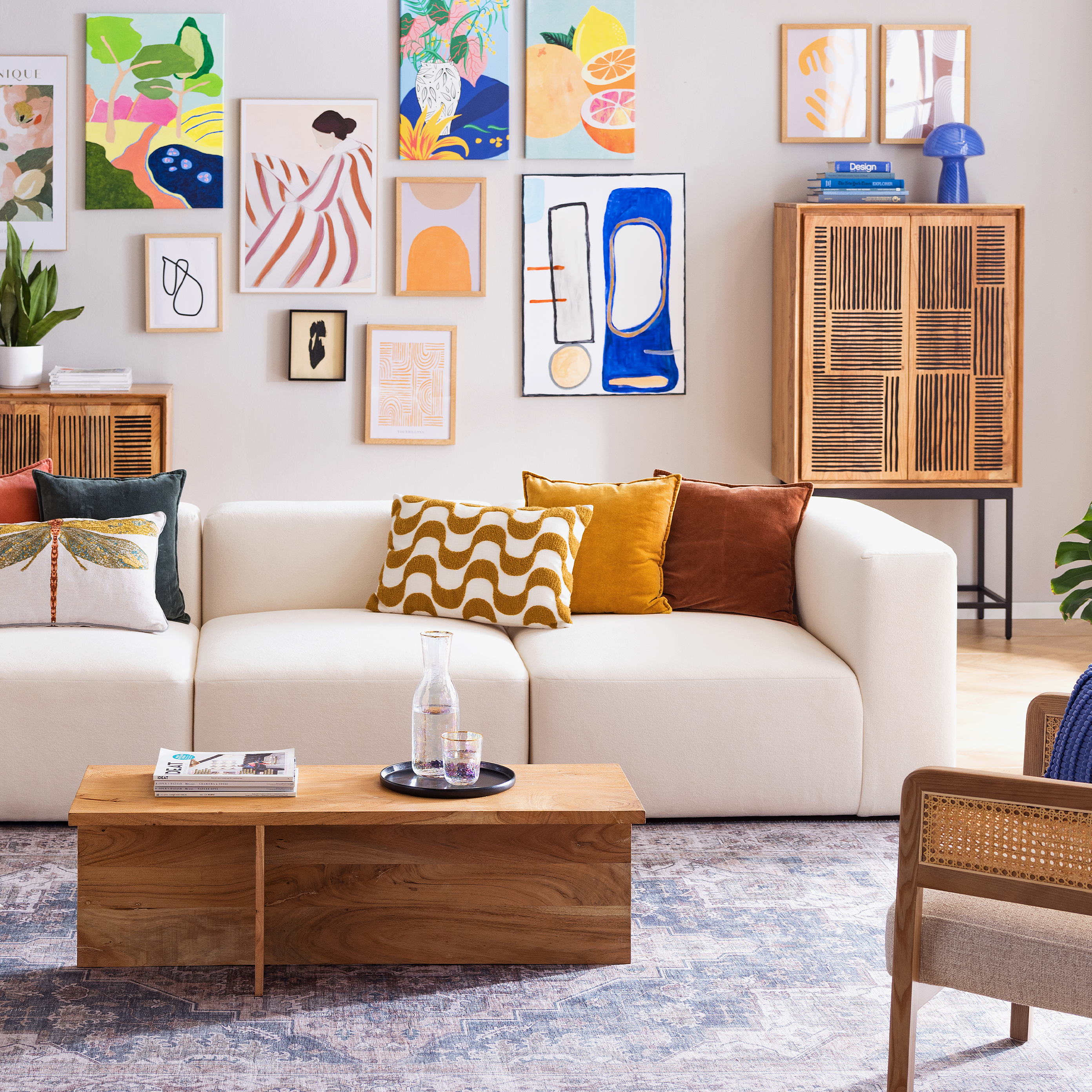 Farbenfroh eingerichtetes Wohnzimmer mit beiger Couch und Echtholzmöbeln.