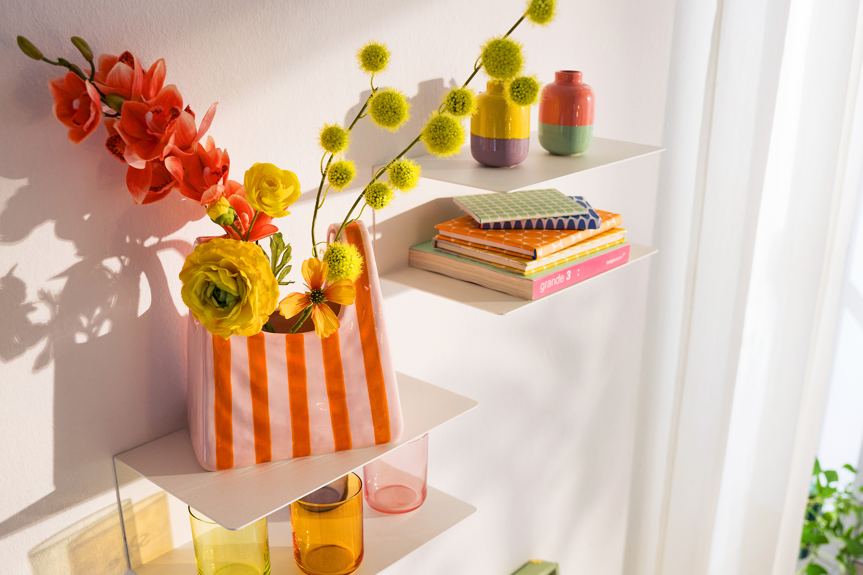 Bunte Vase in Taschen-Optik und farbenfroher Deko.