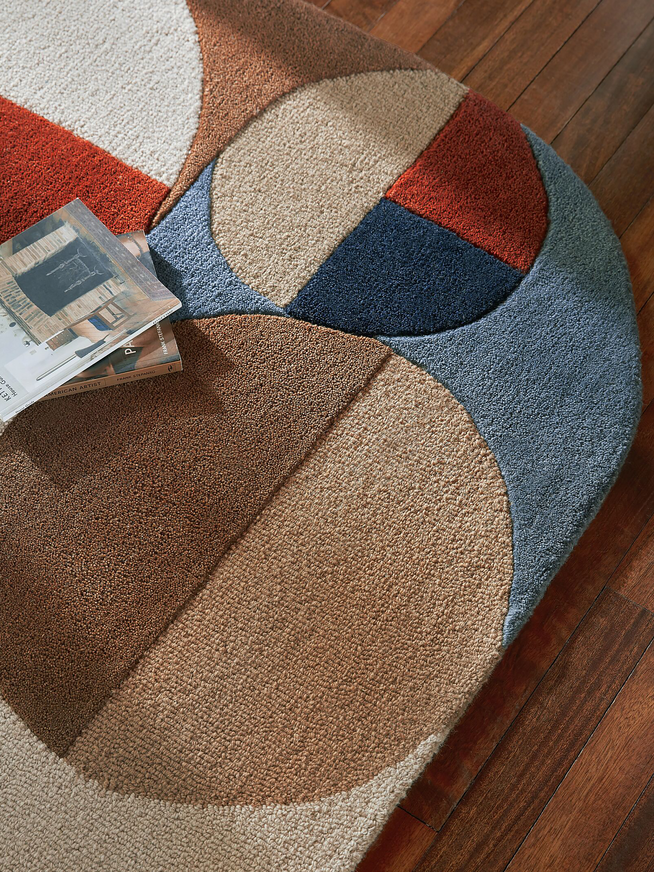 Farbenfroher Teppich in Orange, Blau und Braun.