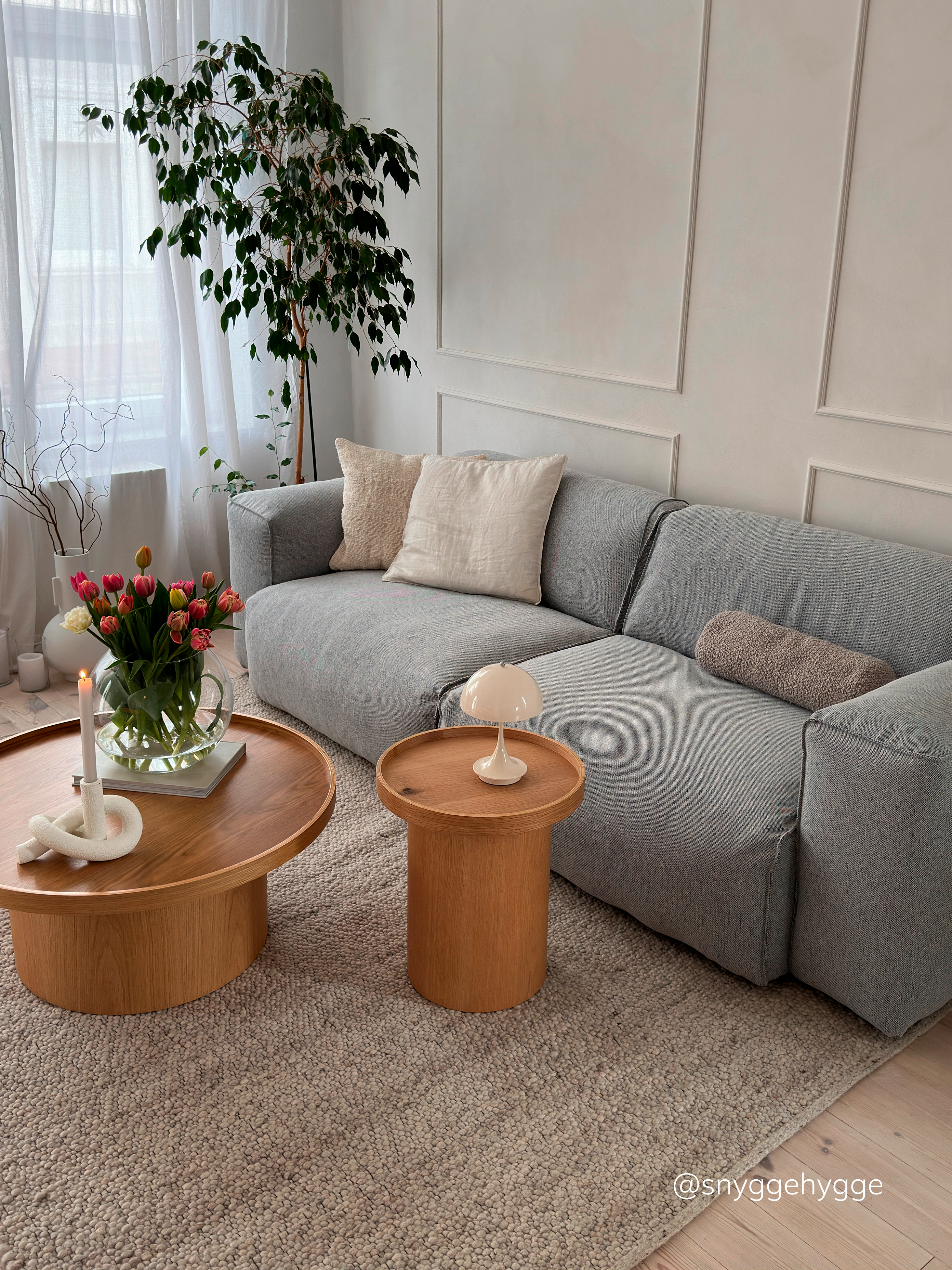 Graues Sofa mit Beistelltisch-Set aus Holz.