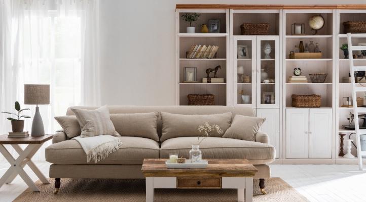 Wohnzimmer im Landhaus Stil mit einem Holzregal von home24 im Hintergrund