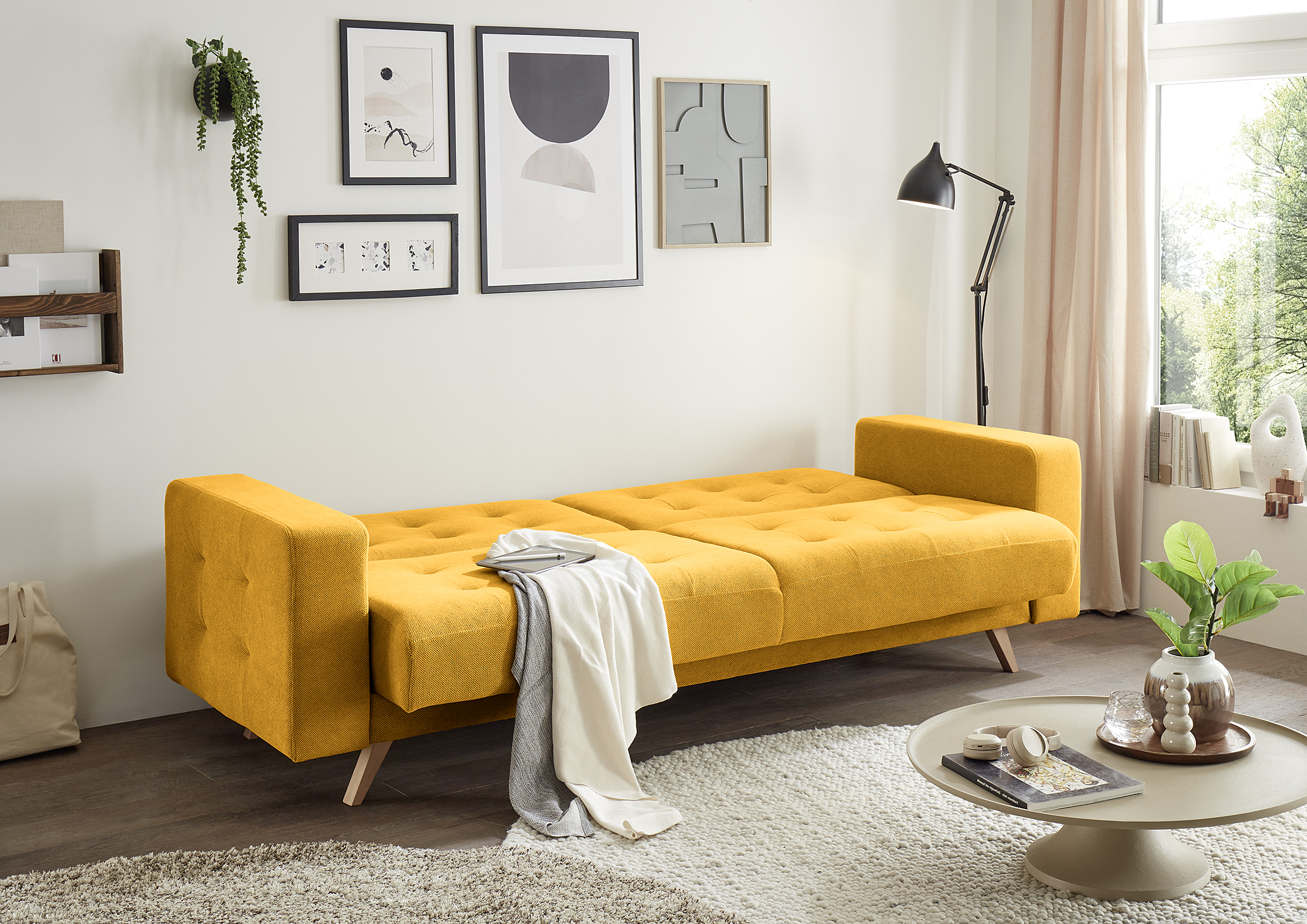 Gelbes Schlafsofa im Chesterfield-Look als Eyecatcher im Gästezimmer.