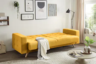 Gelbes Schlafsofa im Chesterfield-Look als Eyecatcher im Gästezimmer.