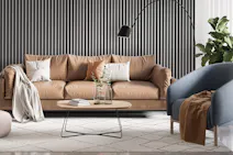 Sitzbereich mit Sofa und Sessel vor einer Wand mit Paneelen