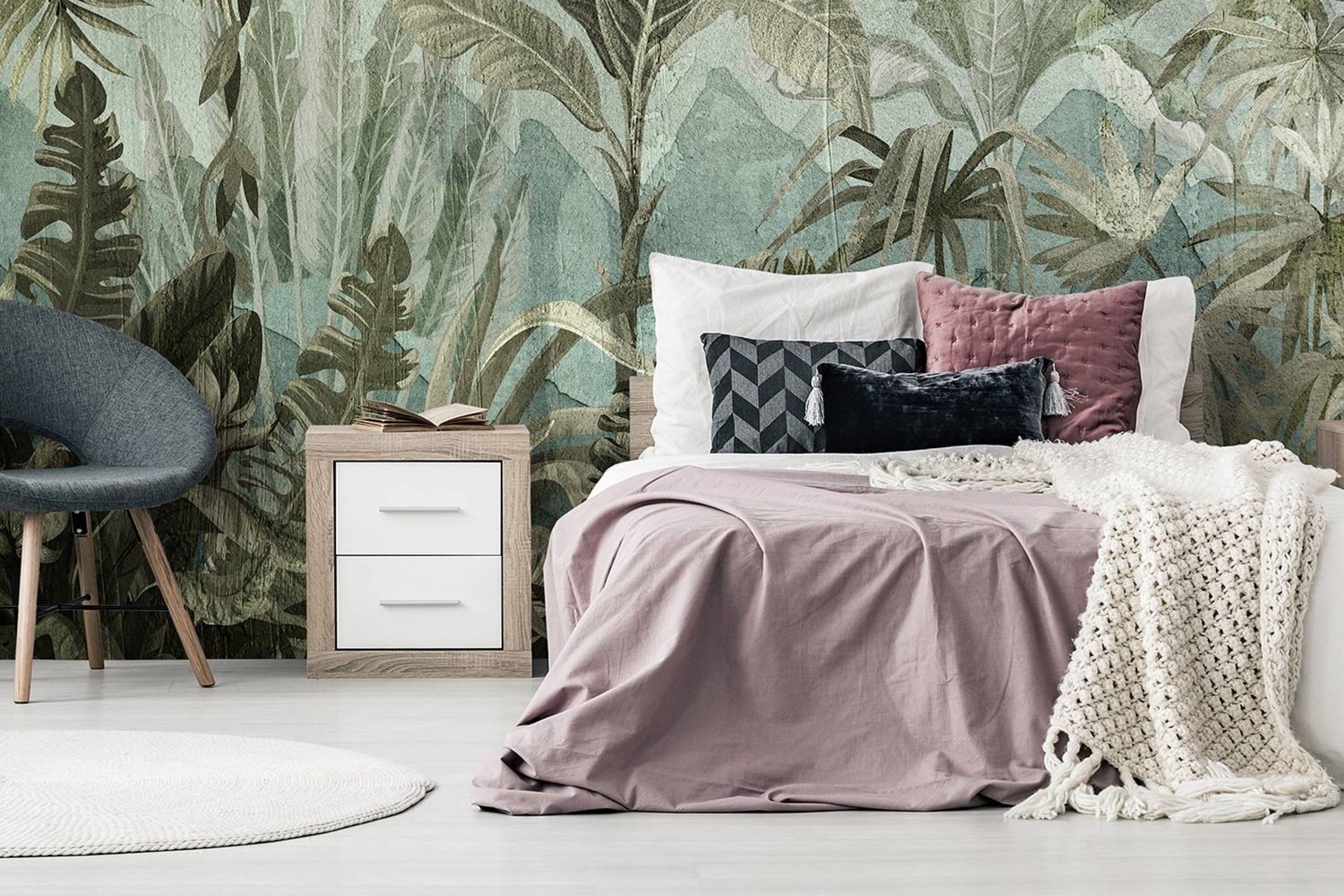 Schlafzimmer mit Dschungeltapete und rosafarbenen Textilien