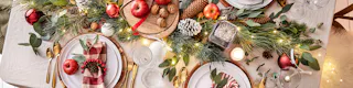 Table dressée pour Noël dans un style traditionnel avec du rouge, du doré et du bois.