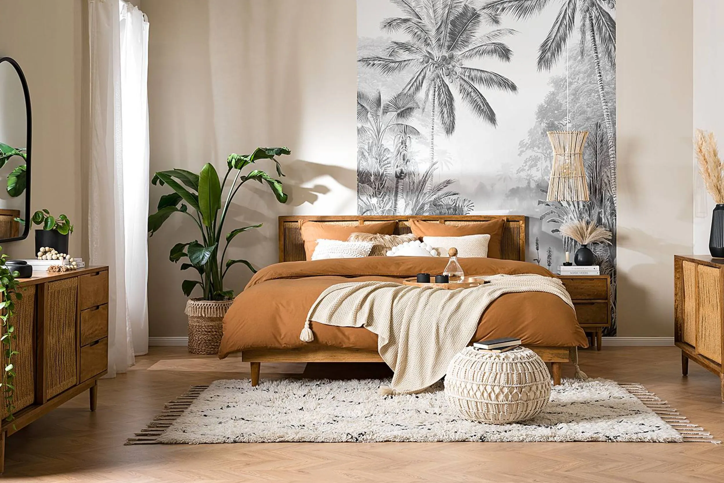 Schlafzimmer im Bohème-Stil mit Holzbett, Terrakotta-Bettwäsche und schwarz-weißer Dschungel-Tapete