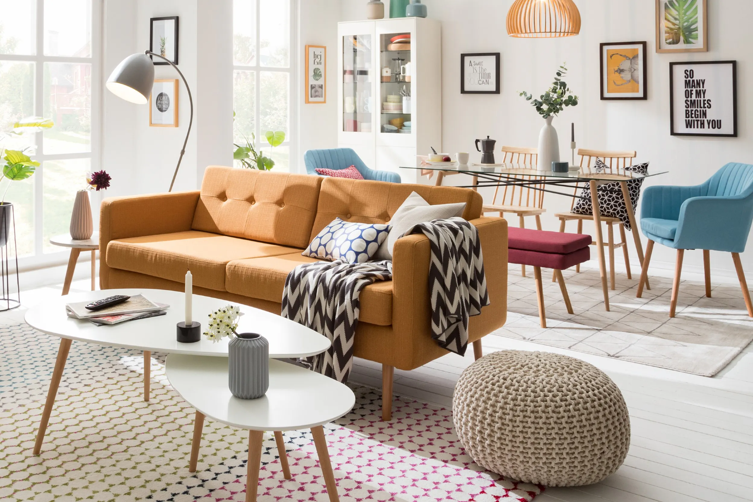 Farbenfrohes Wohnzimmer mit zentral platziertem Sofa, dahinter ein Essbereich