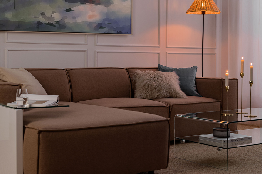 Gemütlich eingerichtetes Wohnzimmer mit Sofa KINX von Exklusivmarke Studio Copenhagen in der Pantone-Trendfarbe 2025 Mocha Mousse.