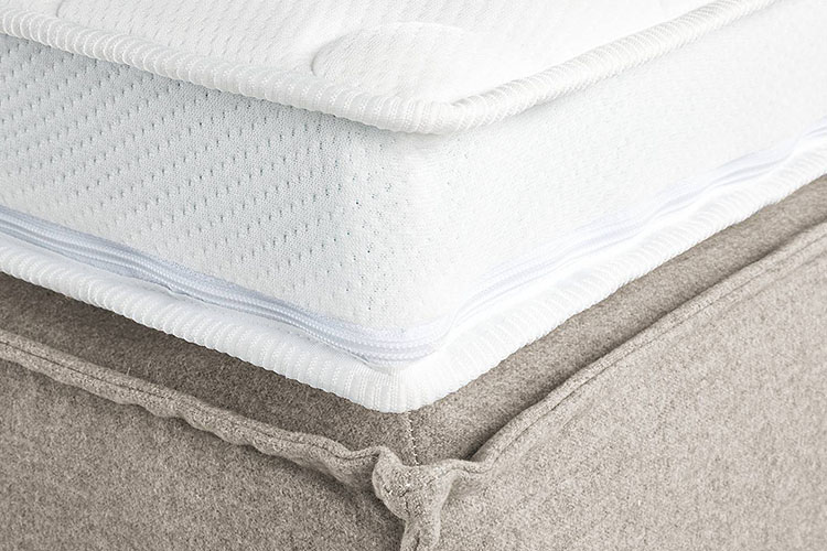 Detailbild eines Matratzen-Toppers auf einem beigen Bett