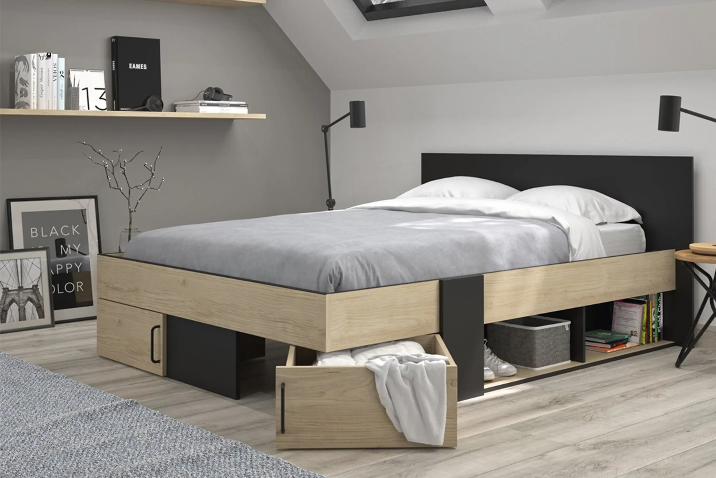 Bett mit Schubladen und Fächern in einem Zimmer mit Dachschräge