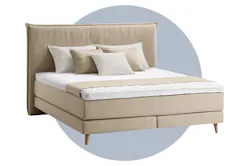 Beiges Boxspringbett Avellino vor einem blau illustierten Kreis