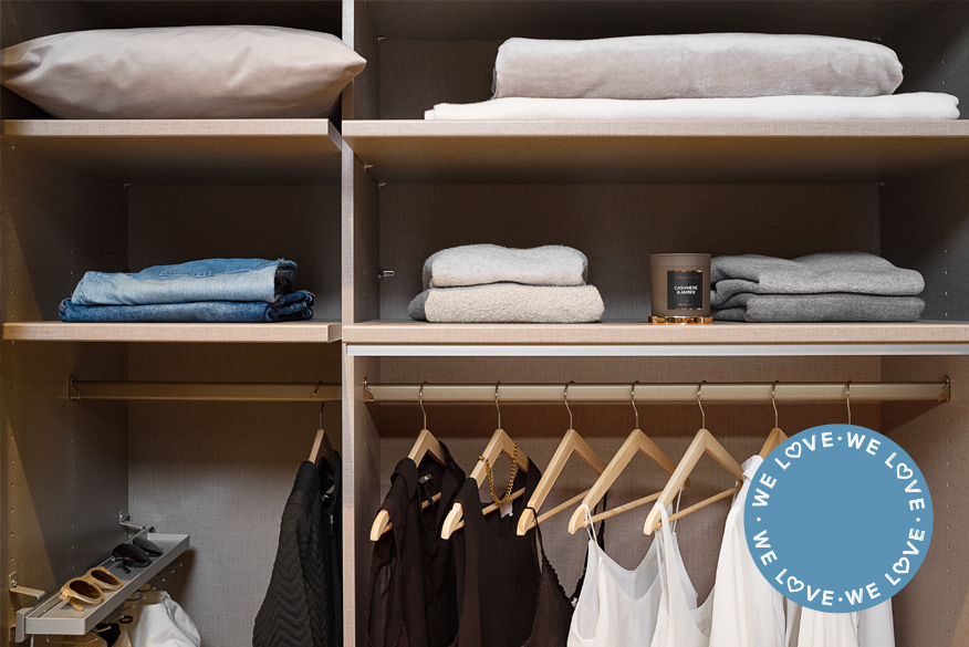 Innenansicht eines perfekt sortierten Kleiderschranks mit hängender und liegender Kleidung