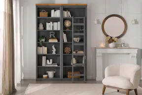 Lesezimmer bzw. eigene Heimbibliothek im Wohnzimmer mit großer Bücherwand inklusive Regalleiter, einladenden Lesesesseln und Sofas sowie gemütlichen Textilien und Deko.