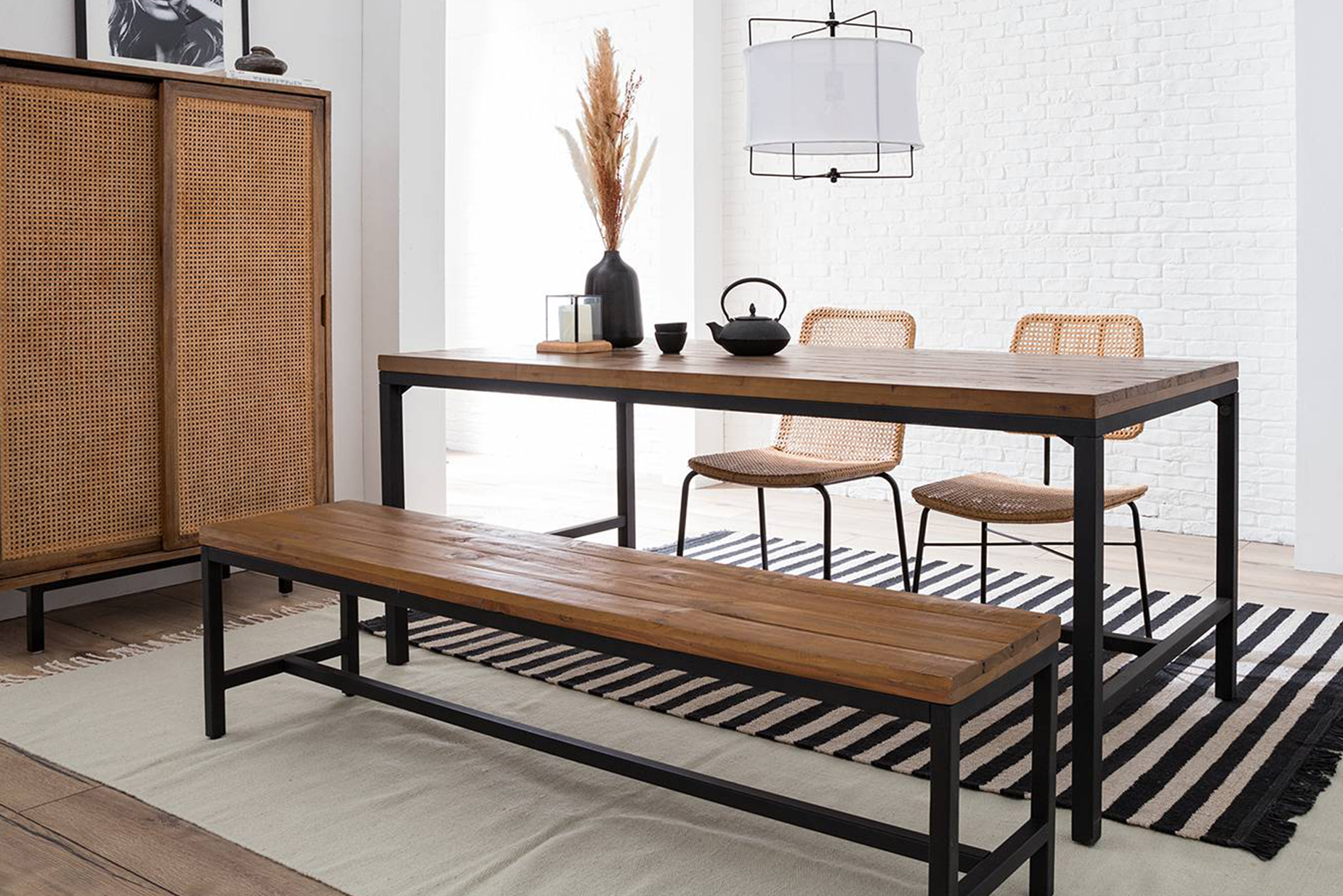 Esstisch und Sitzbank im typischen Industrial-Stil von der Serie Grasby by kollected aus recyceltem Massivholz mit streng wirkendem Metallrahmen.