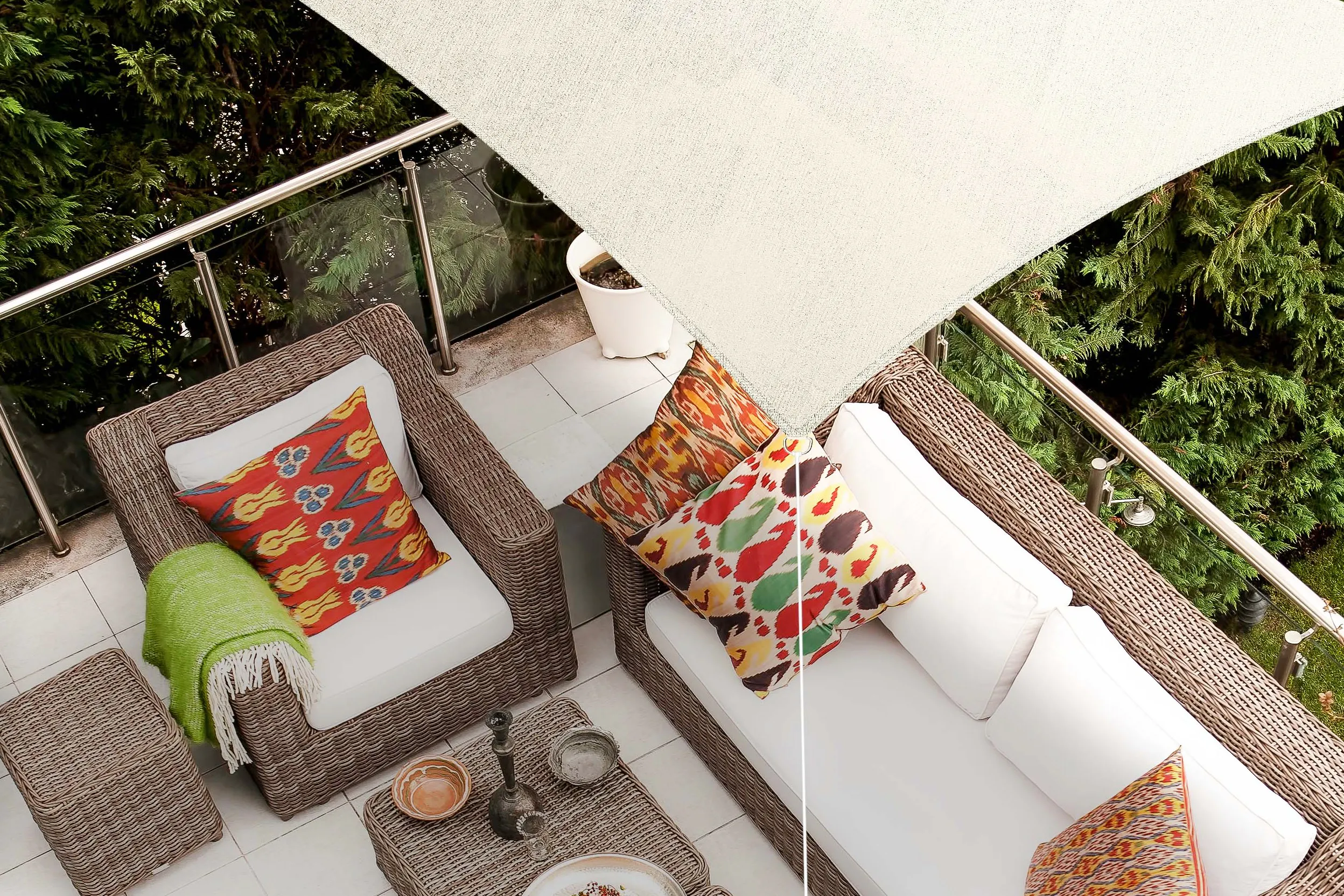 Lounge mit bunten Kissen auf einem Balkon mit Sonnensegel